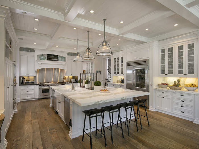 The largest kitchen out of four on the property features reclaimed French oak floors, a Calacatta marble-top island, and a breakfast room with an automatic pocket door.