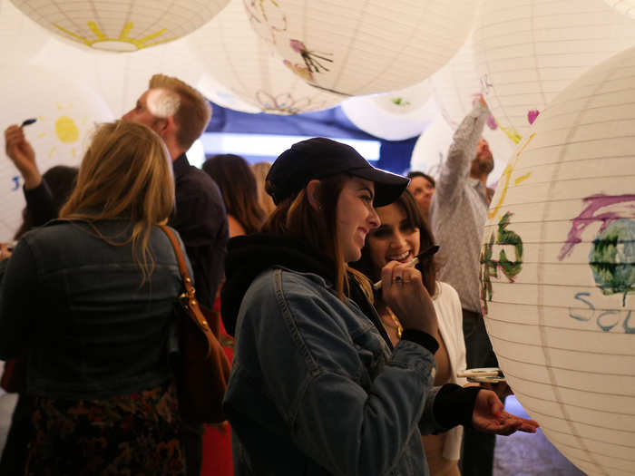 Refinery29 collaborated with LA-based non-profit art collective The Art of Elysium for the "Art Heals" exhibit, featuring a cluster of white paper lanterns. They were pristinely clean until guests made their personalized marks on the installation.