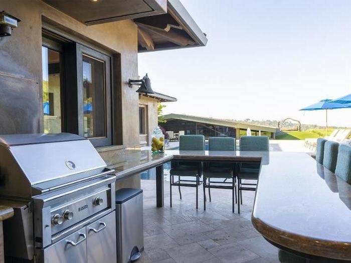 There are plenty of amenities for entertaining in the backyard, like outdoor seating and a grill for barbecuing.