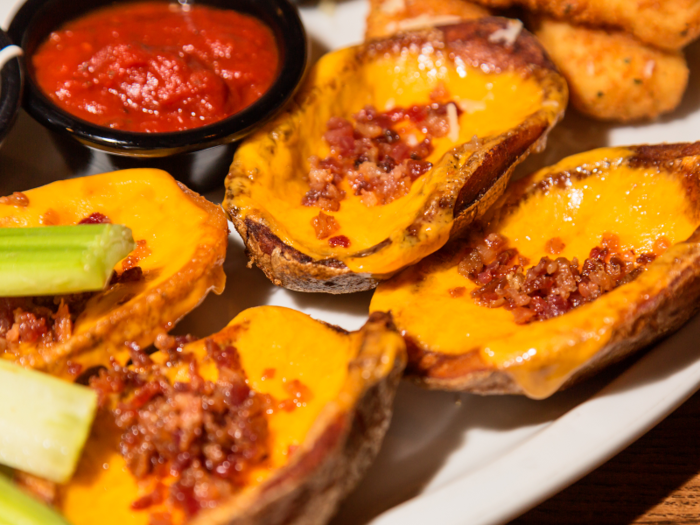 After the wings and the mozz sticks, the two chains diverge in their app offerings. TGI Fridays serves up a hearty plate of loaded potato skins.