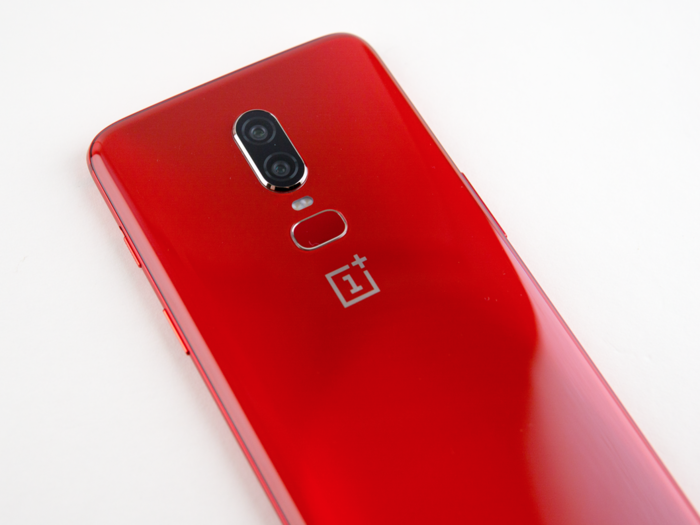 The fingerprint scanner on the back contrasts with the red of the phone, and it