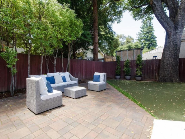 A section of putting green sits next to a set of lounge furniture.