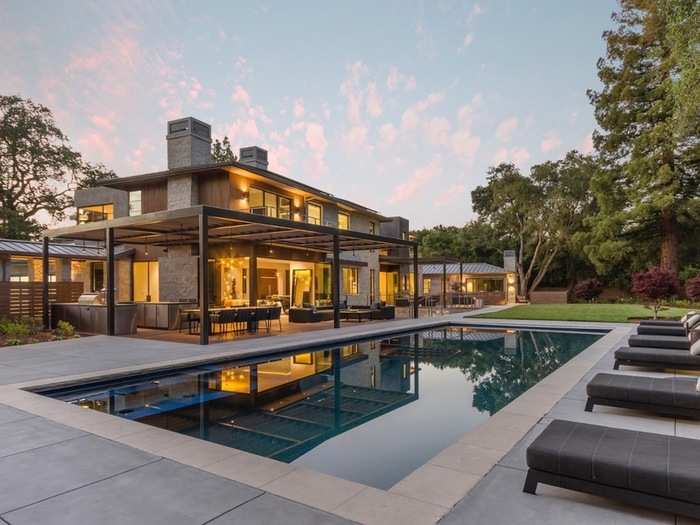 A serene pool and lounge area rests in the backyard.