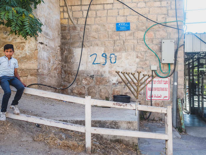 Both Israeli settlers and Palestinians live in Tel Rumeida. Many of the Palestinian families that live in the neighborhood make a living by working the land for agriculture. But soldiers are never far away. I took this photo after a soldier shooed me away from photographing the checkpoint, which is just out of the frame.