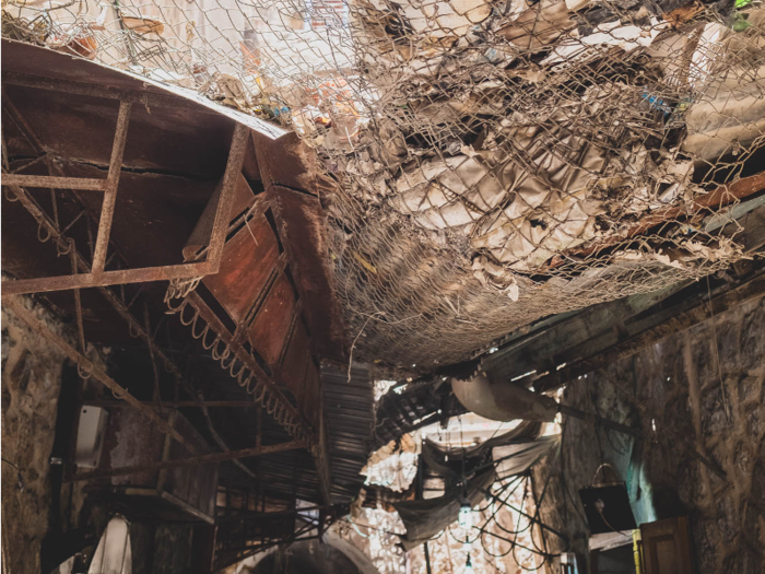 Israeli settlers frequently throw their trash onto the Palestinians below — everything from garbage to urine and sewage, Maraqa said. The shop-owners put up the metal netting to block the trash. "It all happens in front of the soldiers