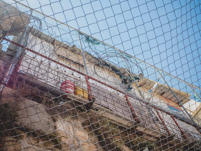 Military checkpoints manned by soldiers tower over the area. Israeli settlers live in apartments above the Palestinian shops of the Old City. The two are separated by barbed wire and metal netting. "I don