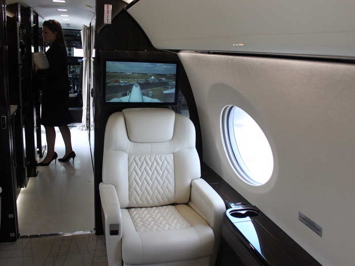 At the front of the cabin is a large entertainment screen. The plane is equipped with a complete in-flight entertainment system including high-speed Wifi.