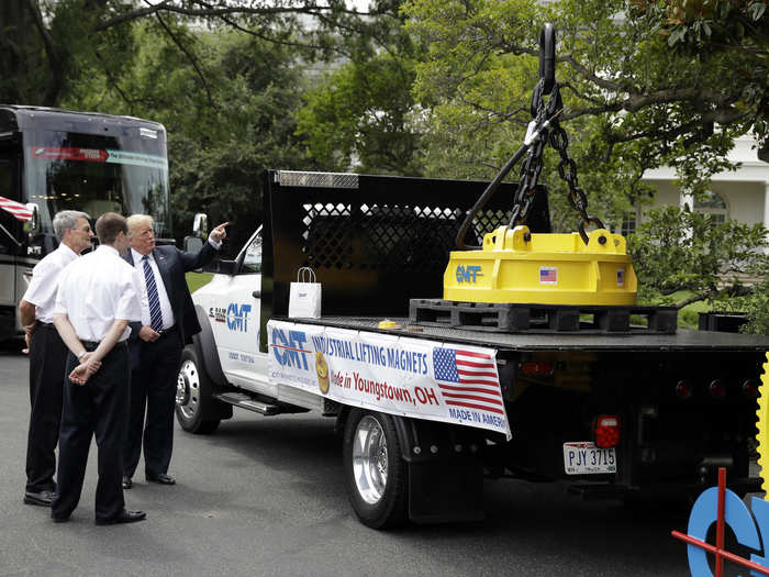 Trump talks with representatives from the Ohio-based industrial magnet manufacturer City Machine Technologies, next to an industrial magnet.