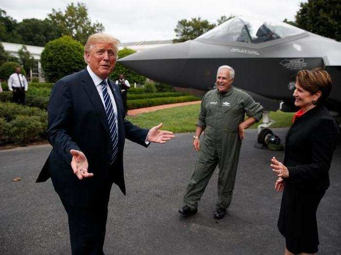 Trump talks with Lockheed Martin president and CEO Marilyn Hewson, right, and an F-35 test pilot, middle, in front of Lockheed Martin