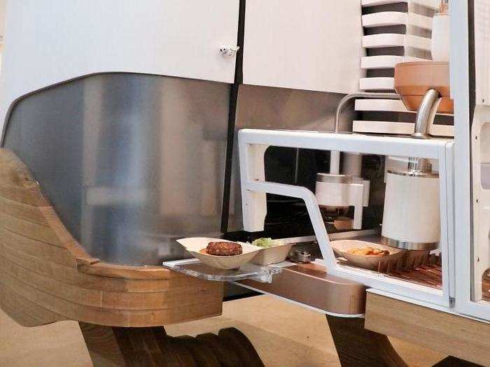 While the bun gets all the fixings, the robot grinds the meat to order. It takes place in this opaque case, so guests don