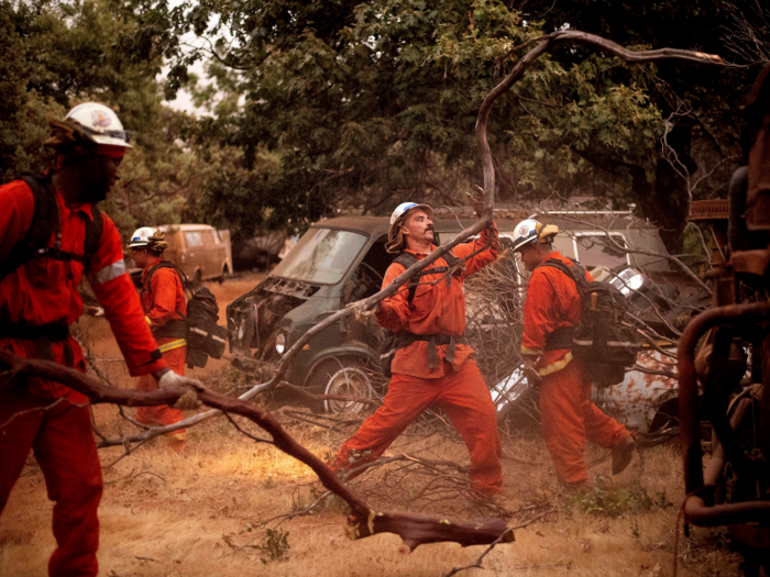 Inmate firefighters from California state prisons have been enlisted to clear brush to create fire breaks — strips of open land that fires can