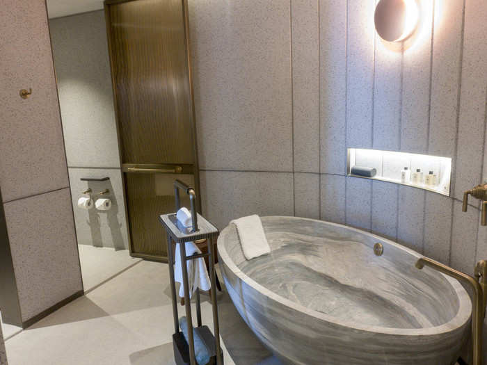 The bathtub in the master bathroom is a deep soaking tub made from a single piece of marble. It