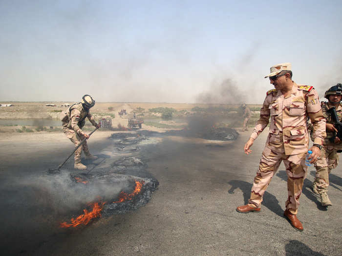 An Iraqi Security forces tries to put out burnt tires during a protest in the West Qurna 2 oilfield in north of Basra, Iraq July 26, 2018.
