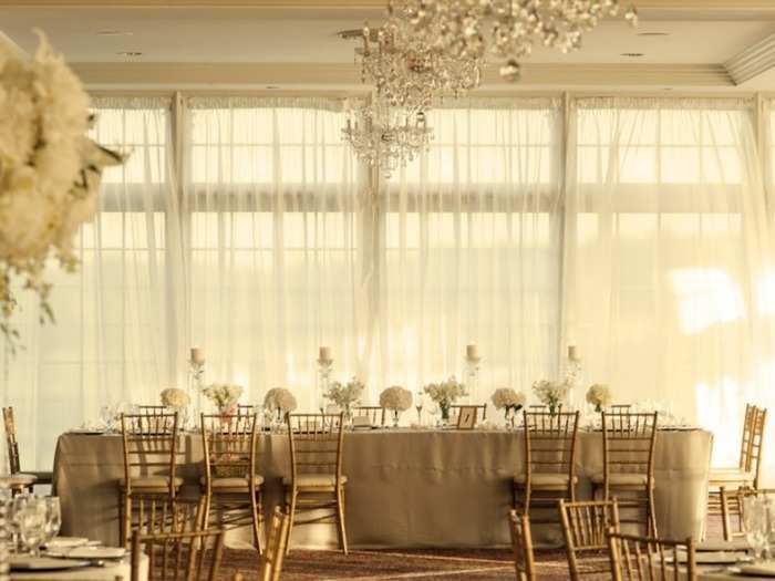 The 5,000-square-foot ballroom can seat 300 guests and features glass windows, French doors, crystal chandeliers, gold chairs, a dance floor, and 11-foot ceilings.