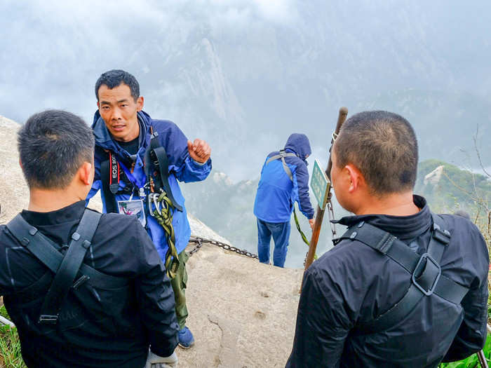 The instructor explained how the harness works. Basically you hold two carabiners attached to ropes. As you descend, you have to unclip the carabiners one by one and reattach them below each bolt in the mountainside. If you accidentally unclip both carabiners at once, it