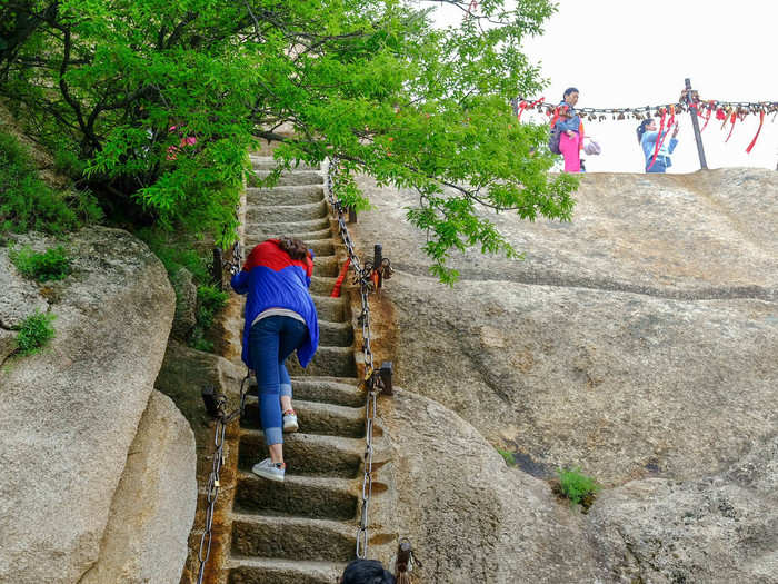 There are "sky ladders" cut into the side of the mountain that you can use as a shortcut. While the path is directly underneath this, if you slip, you could fall a long way.