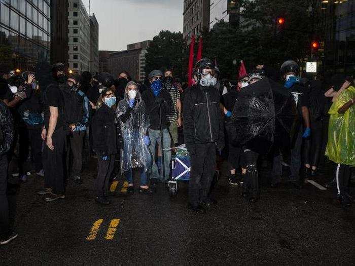 As rain began to fall, the counter-protesters remained unfazed, pulling ponchos and umbrellas out to cover themselves and one another.