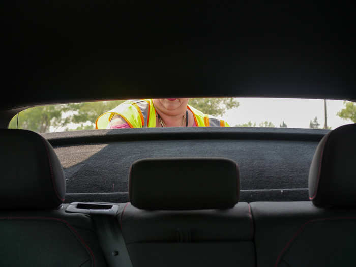 Minutes later, an employee showed up with a green cart full of my groceries. She could see on a phone she had that there was alcohol in my order, so she stopped at my window to check my ID. Then she wheeled my order to the trunk, opened the hatch, and placed my brown-bagged groceries in.