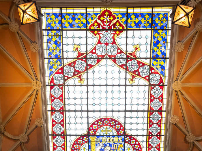 The center of the ceiling is dominated by a stained-glass skylight inscribed with the store