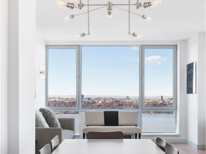 Floor-to-ceiling windows line most exterior walls of the apartment.