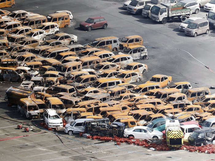 About 100 cars at a coastal dealership in Nishinomiya caught fire during the storm on Tuesday after the flooding caused them to short circuit.