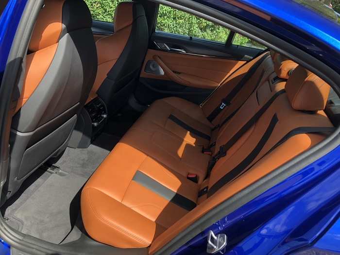 The M5, for all its beastliness, is still based on the 5-Series, which can be used as a modest executive limo. So the rear seats, while a bench design, are comfortable and roomy.