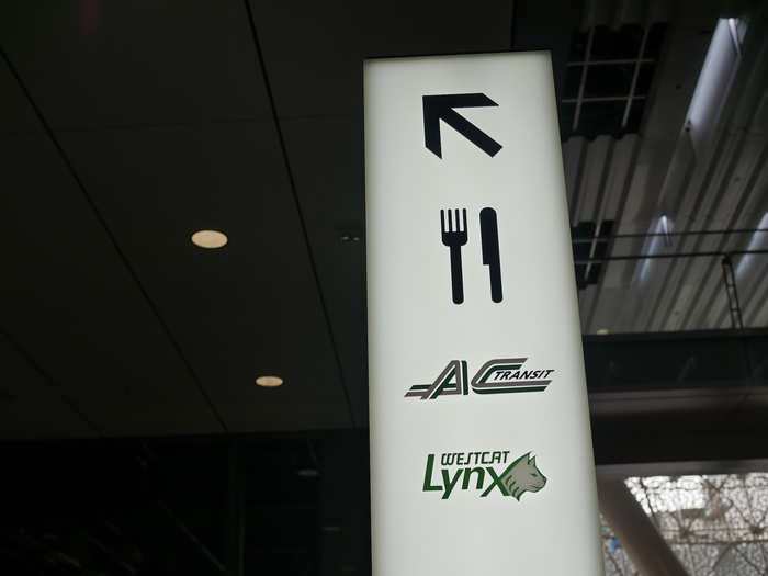 Inside the station, lit pillars indicate where commuters should go, with food and transit lines one way ...