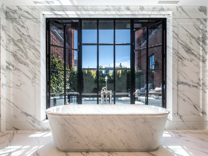 The marble bathtub looks out into the private terrace.