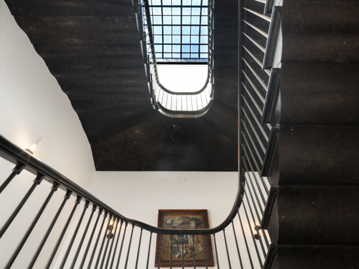 A black marble staircase leads to the level of the master bedroom suite.