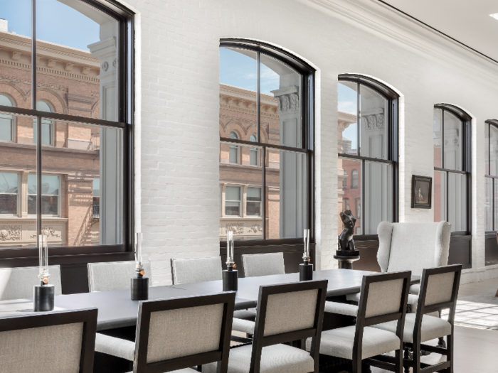 A long dining table sits underneath one of the skylights.