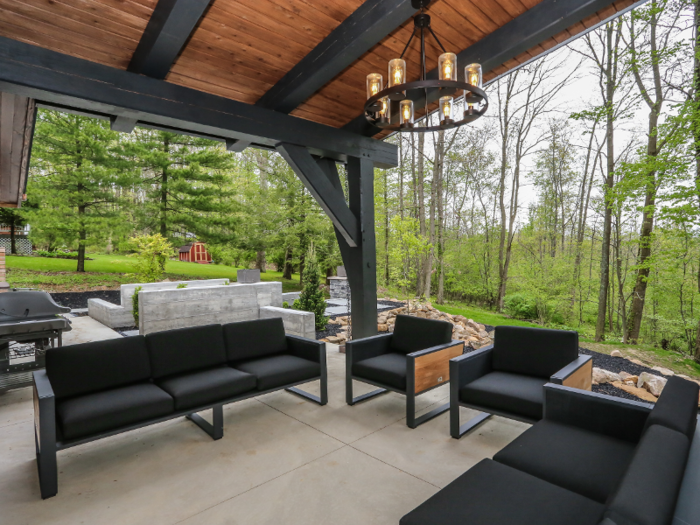 Outside is a built-in fire pit with attached seating, a grill, and a hot tub.