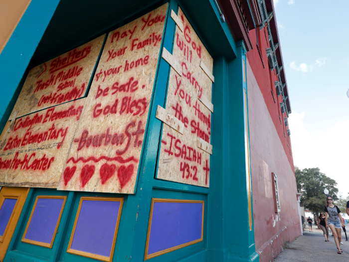 Some of the boarded up windows include information about nearby shelters.