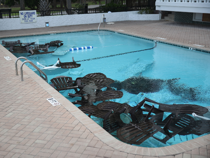 Here, patio furniture has been placed in a pool to keep it from flying away during the storm.