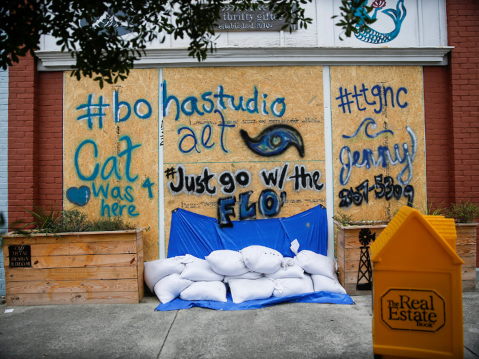 Store owners have boarded up their windows and left sandbags in front of door frames to limit the damage.