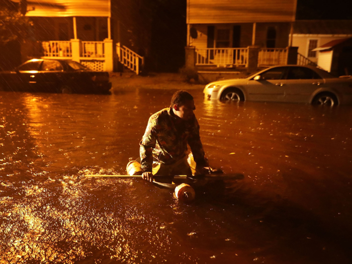 Michael Nelson, who lives in New Bern, is floating in a makeshift boat of metal tub and fishing floats after the Neuse River flooded his street.