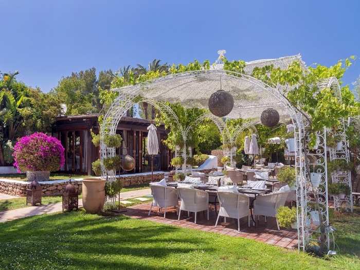 The restaurant is surrounded by vines, gardens, and a beautiful pergola.