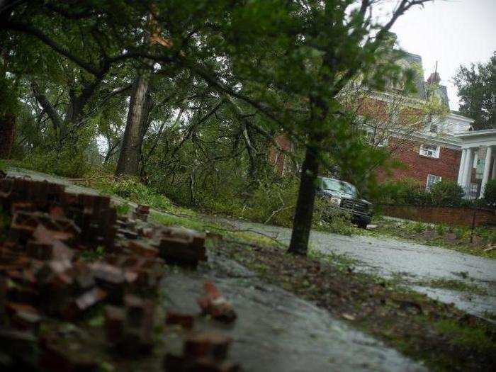 Fallen trees and a damaged brick wall are seen in downtown Wilmington, North Carolina.