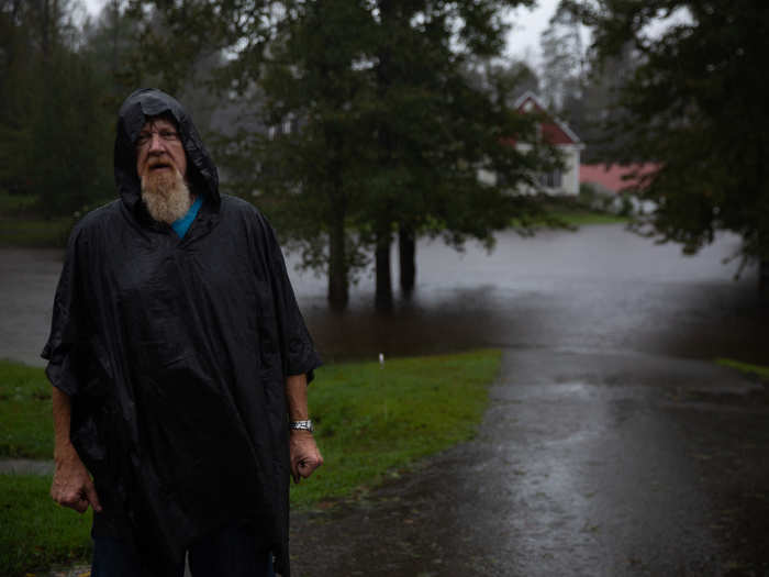 Mr. Walters, 56, anxiously stands outside of his house in Richlands, North Carolina, where the flooded creek in his backyard had created a moat around his home.