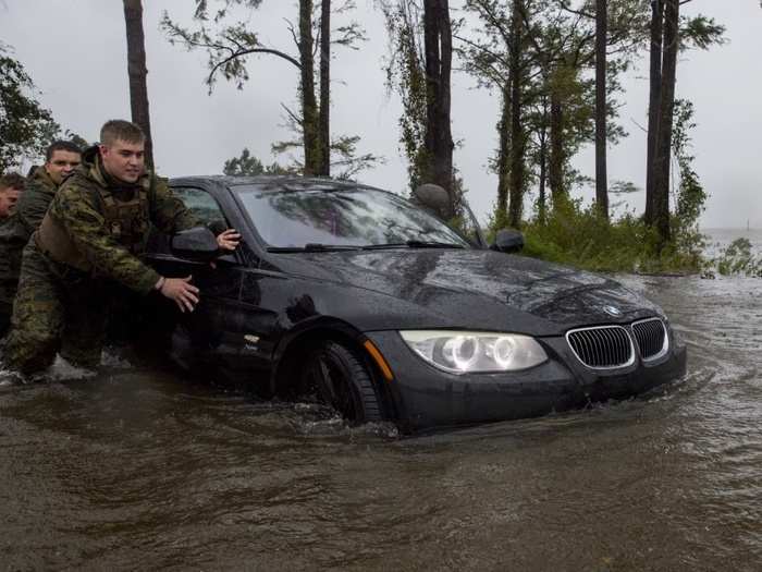 Marines with Marine Corps Base Camp Lejeune help push a car out of a flooded area during Hurricane Florence, on Marine Corps Base Camp Lejeune, Sept. 15, 2018.