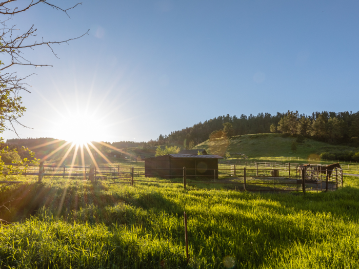 The ranch includes a six-stall barn and numerous corrals for horses.