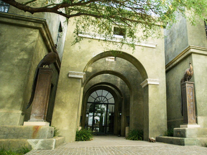 The entryway is flanked by twin peacock statues.