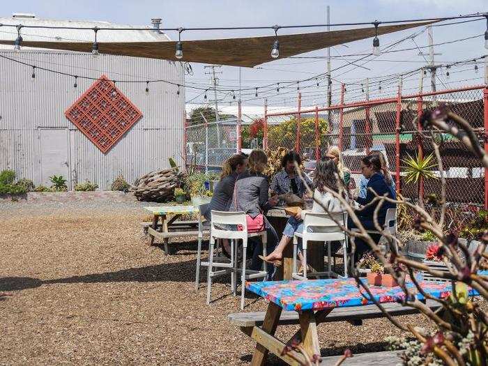 Groups of people sat around eating and enjoying the day.