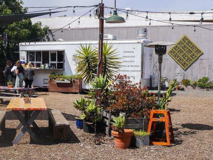 The entire corner lot was decked out in stools, picnic tables, plants of all kinds, eating areas, and strings of large bulbed lights hung over the space.