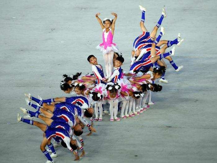 Nearly 17,500 children were recruited to perform the choreographed card display. Many others took part in the acrobatic performances.