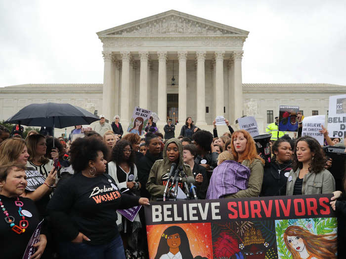 Protesters wore black and carried signs that said #BelieveSurvivors.