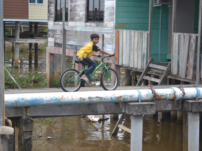 People get around — carefully — on a series of interconnected wooden walkways.