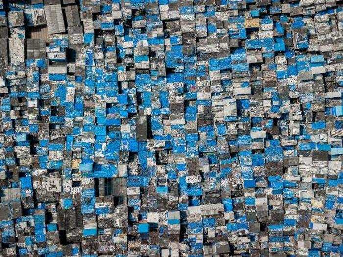 Residents of Dharavi cover their roofs in blue tarps to protect their homes from monsoons.