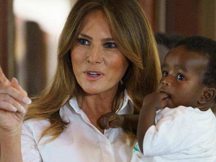 In mother mode, the first lady held several of the babies at the hospital.