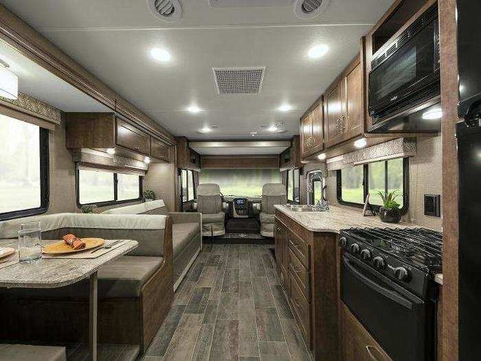 The Winnebago Intent interior features a cozy dinette, 39" HDTV, swivel cab leather seats, three-burner range over, pantry, private rear bedroom, and textured glass shower door.