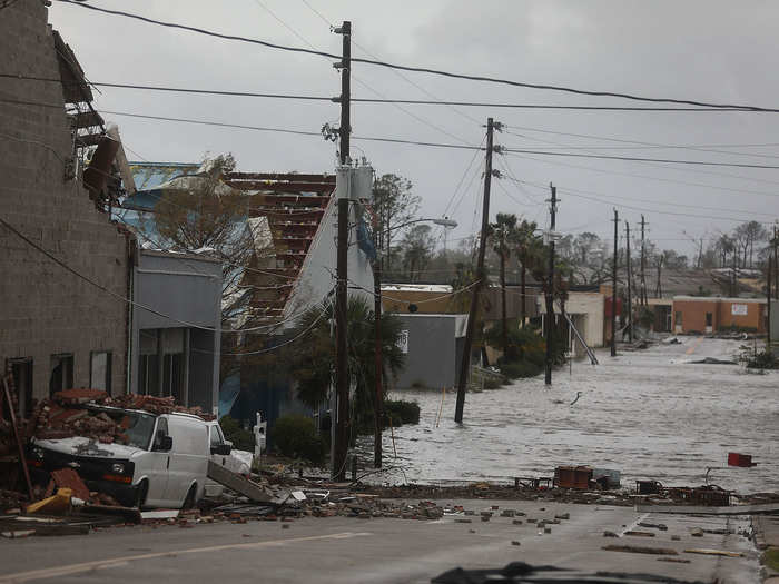 Some photos show roofs ripped off buildings, cars crushed by debris, and flooded roads, like this photo of a road in Panama City.